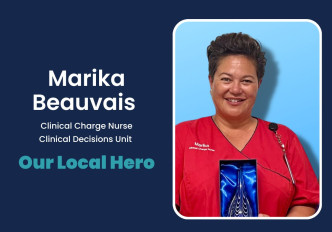 A nurse in a red shirt holding an award